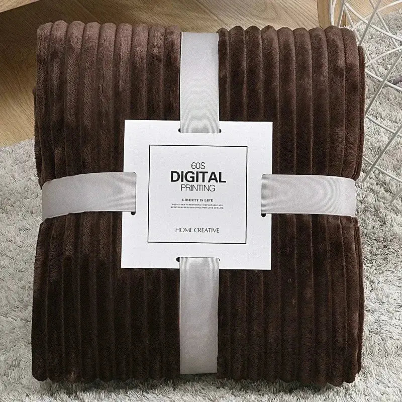 A plush brown corduroy throw blanket with soft ribbed texture neatly wrapped in white ribbon for decorbites cozy striped fleece use