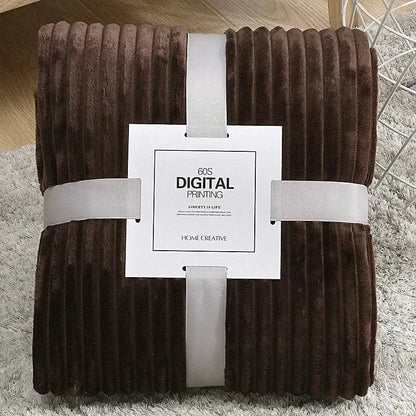 A plush brown corduroy throw blanket with soft ribbed texture neatly wrapped in white ribbon for decorbites cozy striped fleece use