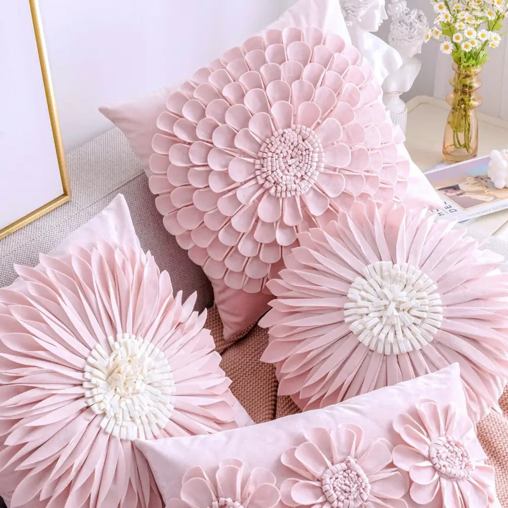 Pink floral throw pillows with layered petals and white embroidered centers on a plush pillowcase decorbites daisy sunflower