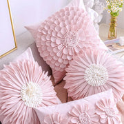 Pink floral throw pillows with layered petals and white embroidered centers on a plush pillowcase decorbites daisy sunflower