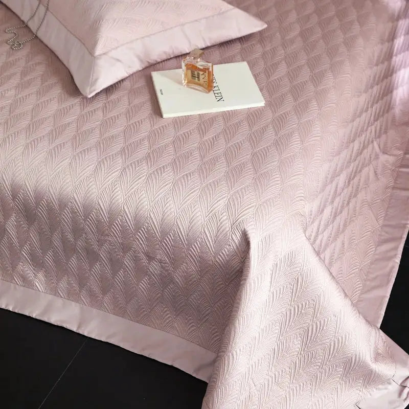 Soft pink quilted bedspread set with subtle feather pattern and satin trim made from decorbites cool lyocell fiber