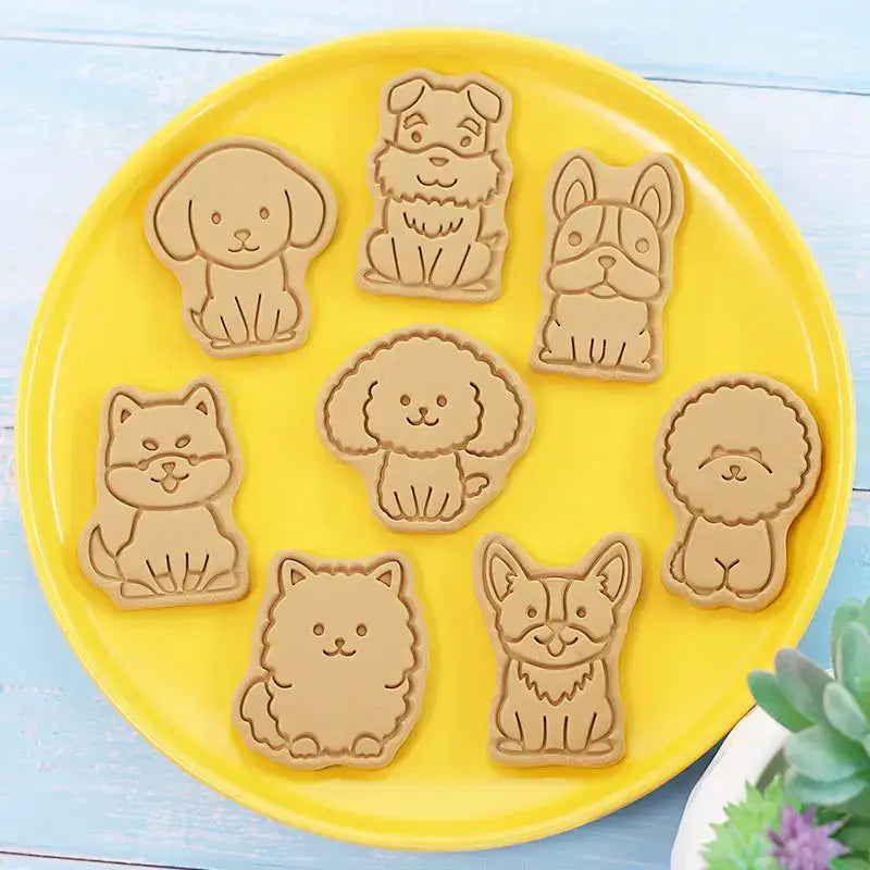 Set of seven beige dog and cat cookie cutters from decorbites 3d dog cookie cutters set on a yellow plate