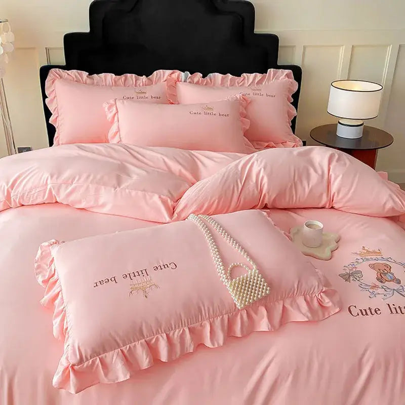 Pink embroidered bear cotton bed skirt set with ruffled edges and cute little bear text in satin bedding