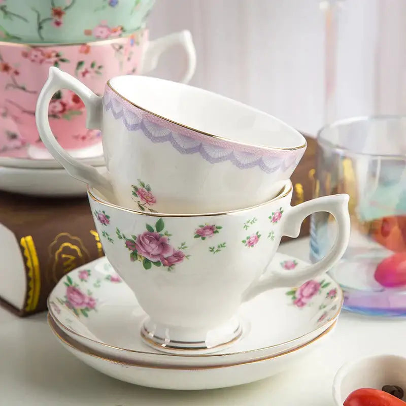 A delicate white porcelain flower tea cup with pink rose patterns and gold trim in a phnom penh afternoon tea cup set
