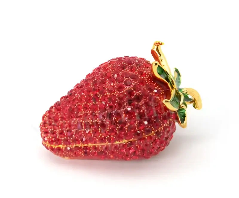 A sparkling red strawberry-shaped rhinestone jewelry trinket box with gold stem and green enamel leaves storage case