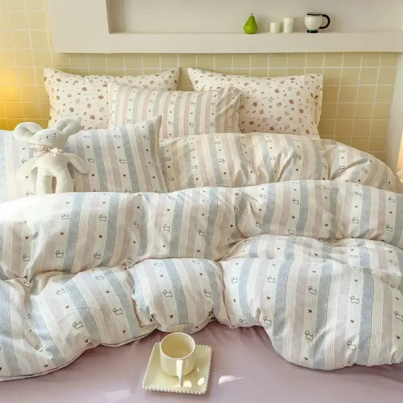 Soft pastel striped duvet set with heart and bunny motifs in light blue paired with pink floral jacquard fitted sheet set