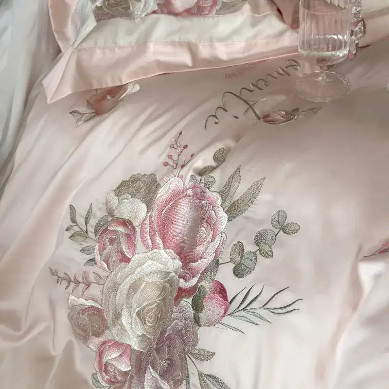 Delicate blush pink satin duvet cover with intricate roses and eucalyptus embroidery in a flowers embroidery bedding set