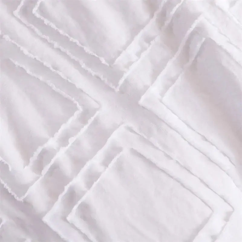 White textured fabric with a geometric quilted pattern of overlapping squares for decorbites geometric cut bedding set