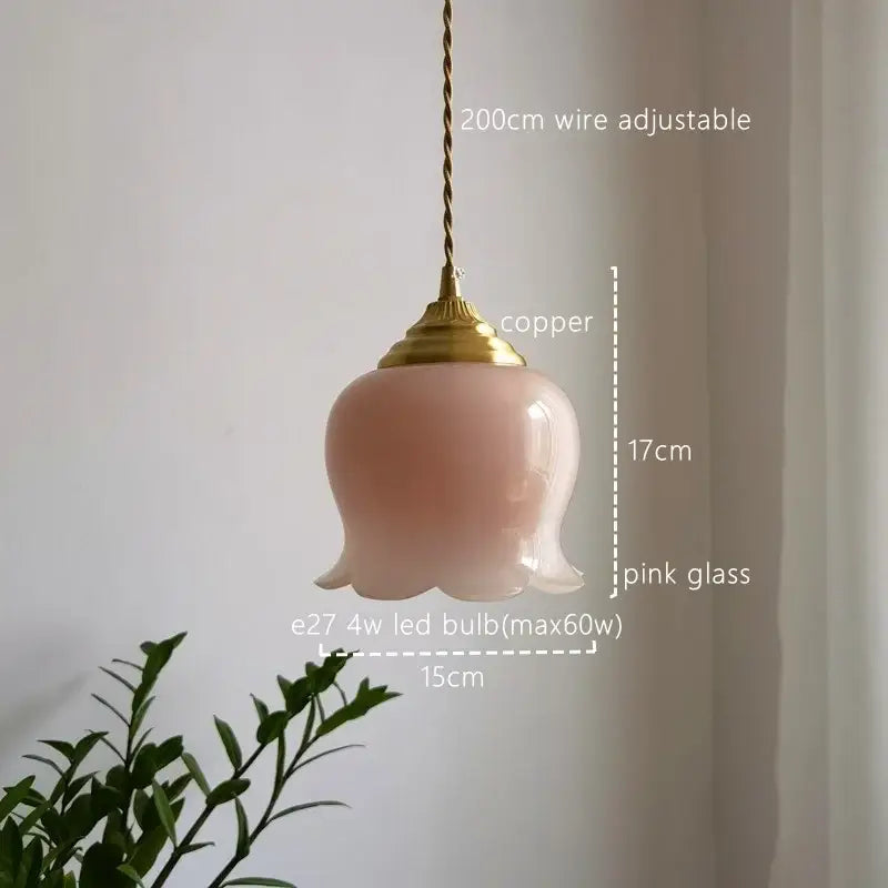 A delicate pink glass copper led pendant light with a twisted wire suspension for kitchen decor
