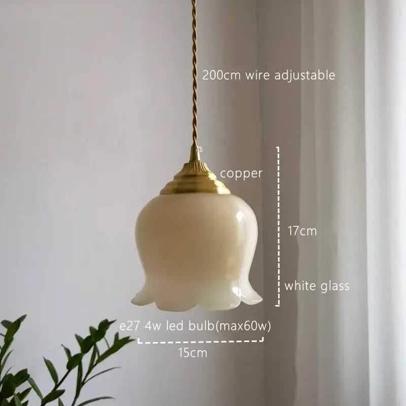 A delicate white glass copper led pendant light with copper finish and twisted wire suspension for kitchen decor