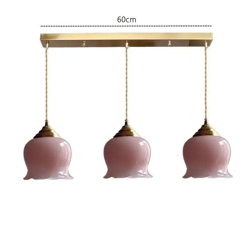 Set of three pink glass copper led pendant lights with gold-toned fixtures ideal for kitchen decor
