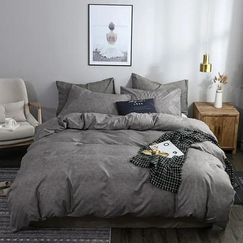 Gray textured cotton duvet cover set with matching pillows and a black and white checkered throw blanket draped over edge