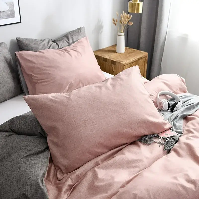 Soft pink linen pillowcases with subtle texture paired with gray pillows in a pink and gray duvet cover set
