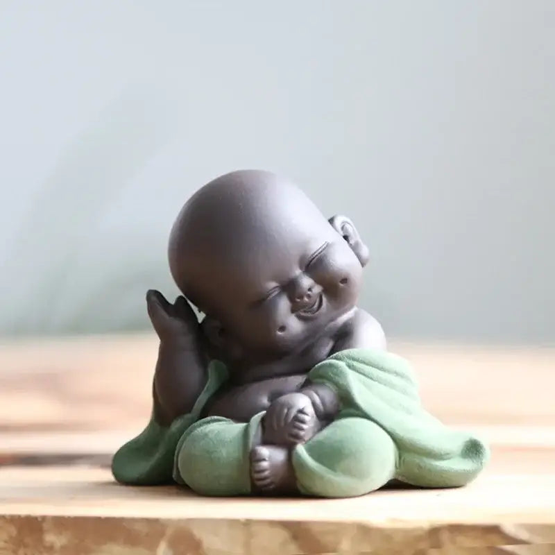 A charming dark gray ceramic maitreya buddha statue tea sculpture wrapped in soft green fabric for living room decor