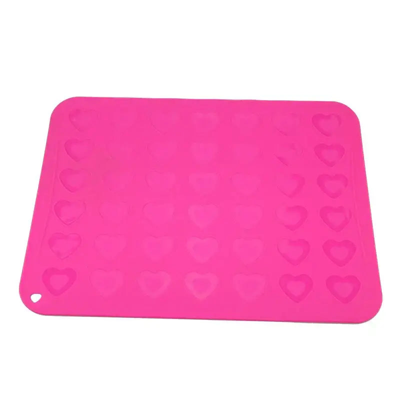 Bright pink decorbites silicone macaron baking mat with heart-shaped indentations for macaron baking and cookie molds