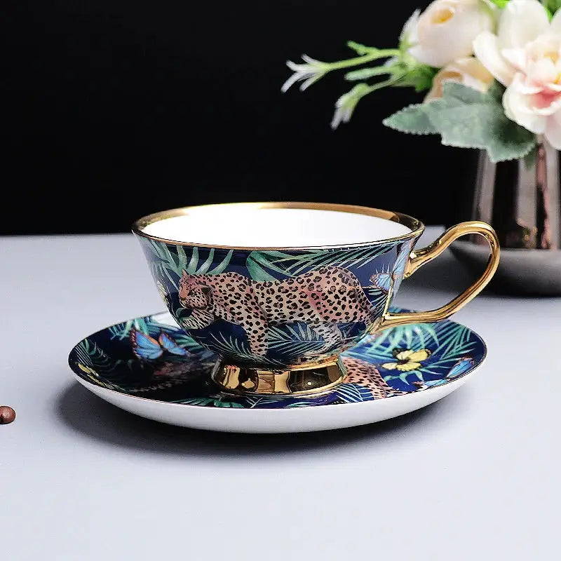 A navy blue bone china teacup and saucer set with detailed jungle animals leopard print and gold trim decorbites jungle animals