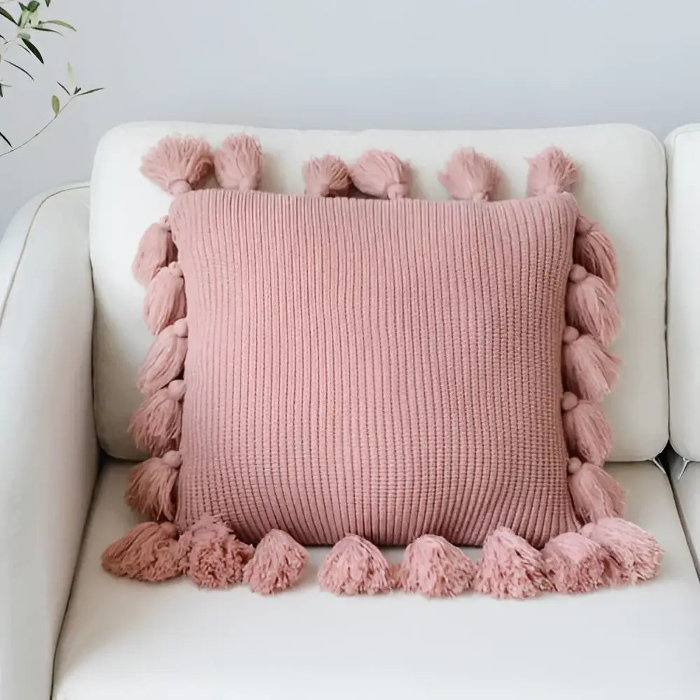 A soft pink decorbites knit cushion cover with fluffy tassels for living room decor and comfort