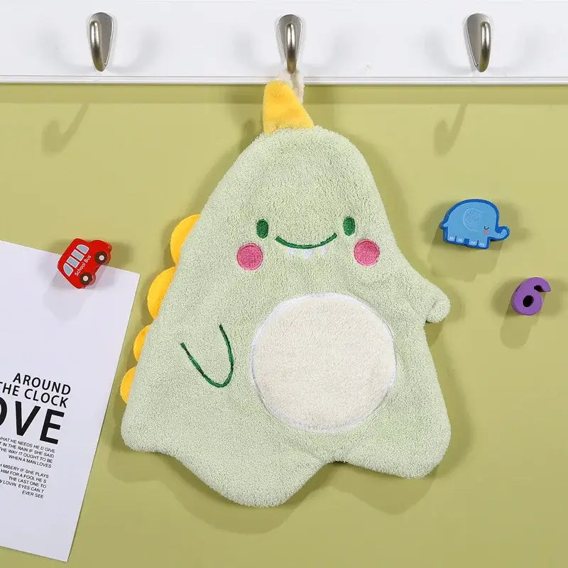A soft light green plush bath towel in dinosaur cartoon animal shape with pink cheeks and white belly patch for decorbites cartoon animal decor