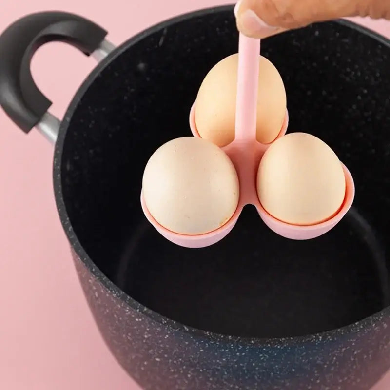 Pink plastic egg steamer tray with three compartments holding brown eggs for kitchen egg steaming use