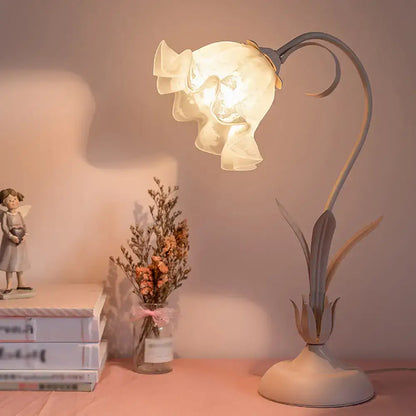 Pink lily cream opal glass table lamp shaped like a blooming flower with ruffled petals on a curved metal stem