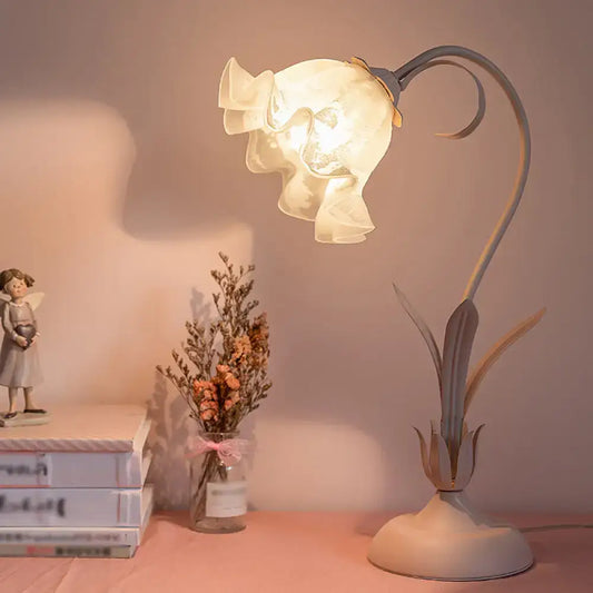 Pink lily cream opal glass table lamp shaped like a blooming flower with ruffled petals on a curved metal stem