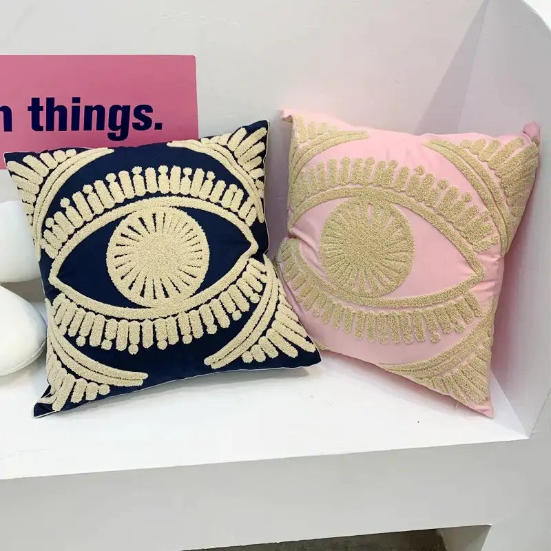 Two embroidered cotton throw pillow covers in navy and pink with eye patterns for living room decor