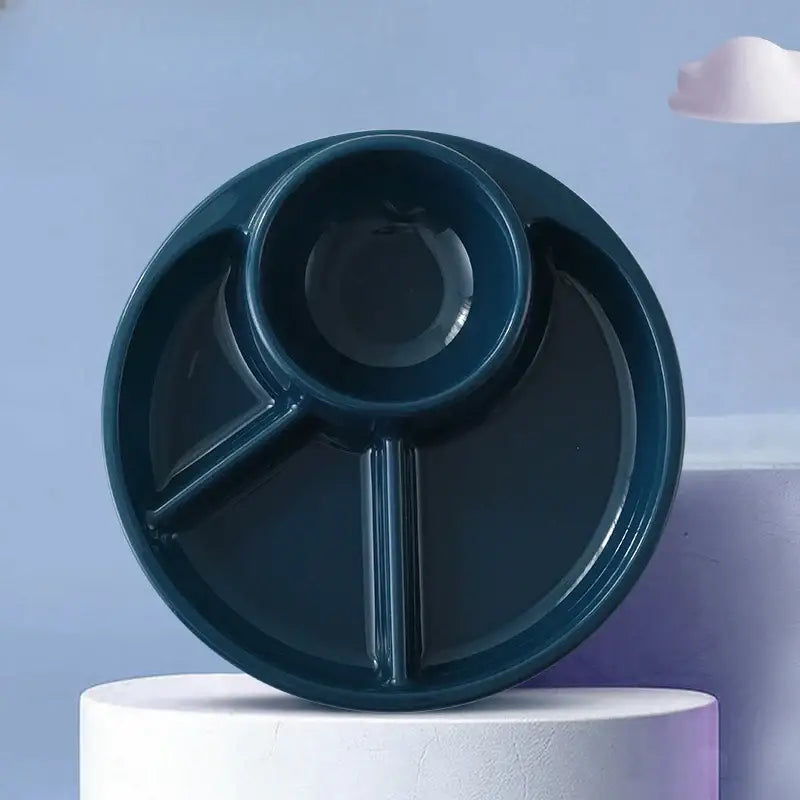 Dark teal ceramic portion control plate with three compartments including a central circular well for kids meals