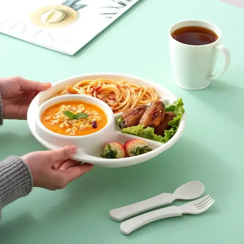 White ceramic divided portion control plate with central bowl holding spaghetti wings and strawberries for kids meal tray