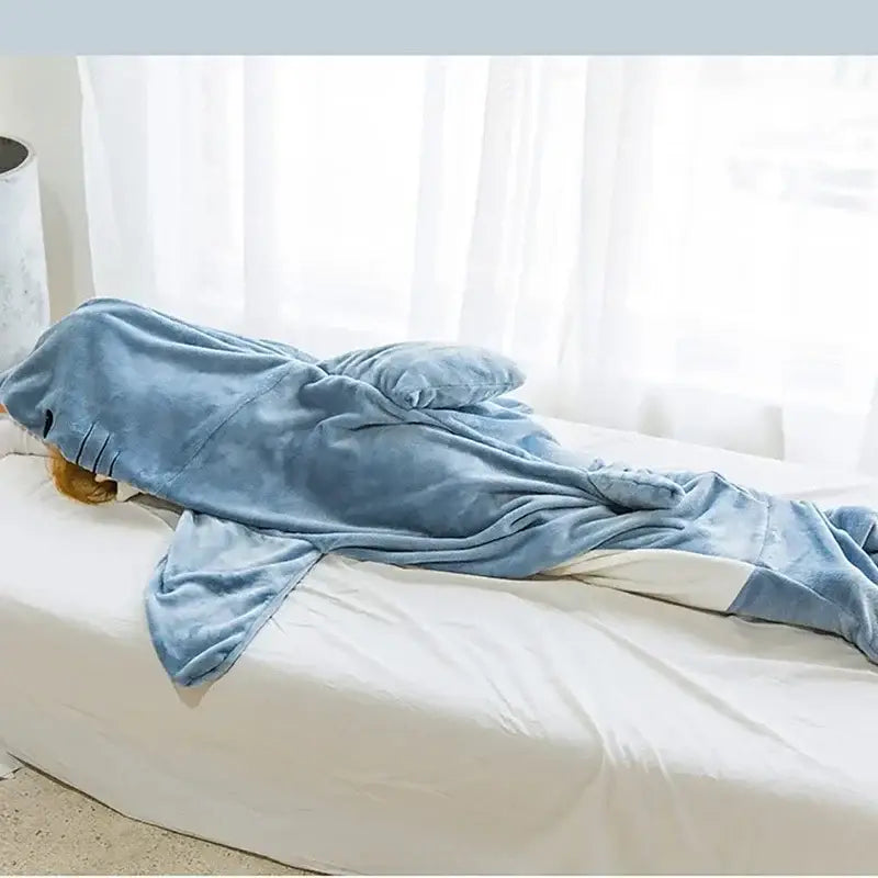 Blue plush cozy shark blanket with white accents on tail and fins in decorbites cozy shark bedroom sleeping bag onesie