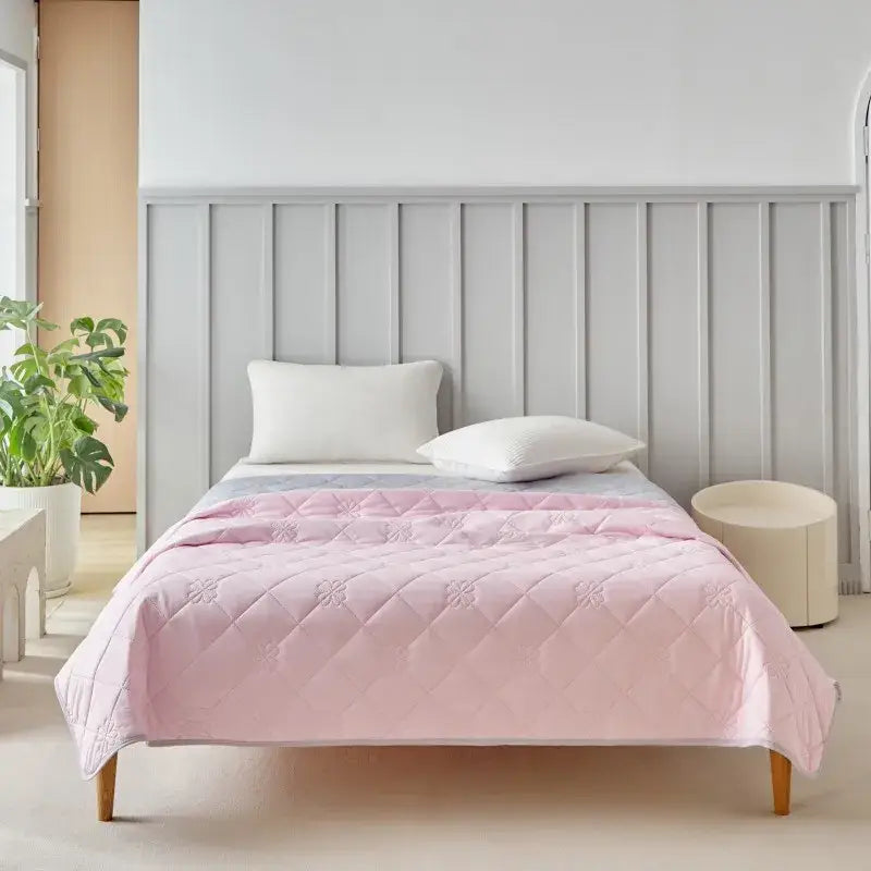 Pink quilted cool summer blanket with subtle floral embroidery and plush texture for bedroom cooling comfort