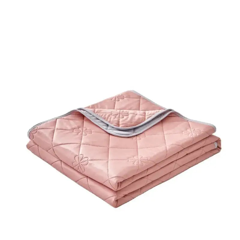 A soft pink quilted cool summer blanket with floral embroidery and gray border for bedroom cooling comfort