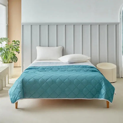 Teal quilted cool summer blanket with diamond pattern and white border for bedroom cooling comfort