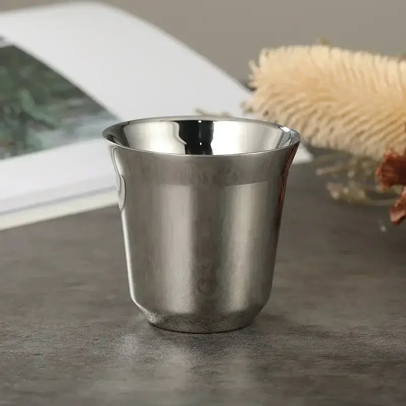 A sleek metallic silver cup from a pink red and green double wall espresso mugs kitchen set of 3 with reflective surface