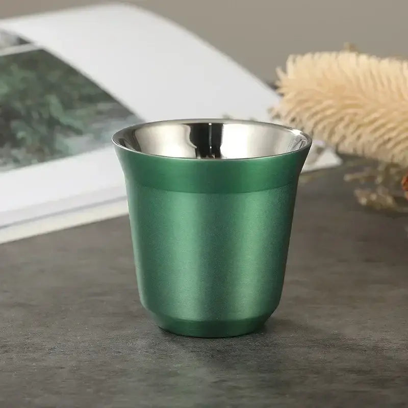A sleek matte green stainless steel shot glass with reflective silver interior from pink red and green double wall espresso mugs set