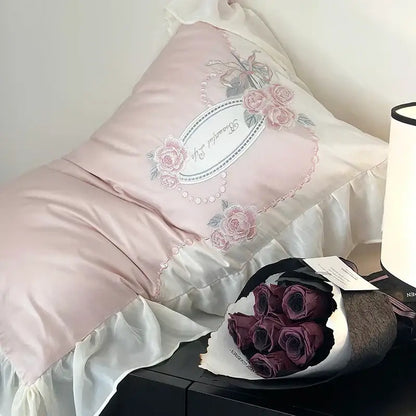 A soft pink satin pillow with delicate floral embroidery and pearl trim from an egyptian cotton flowers bedding set
