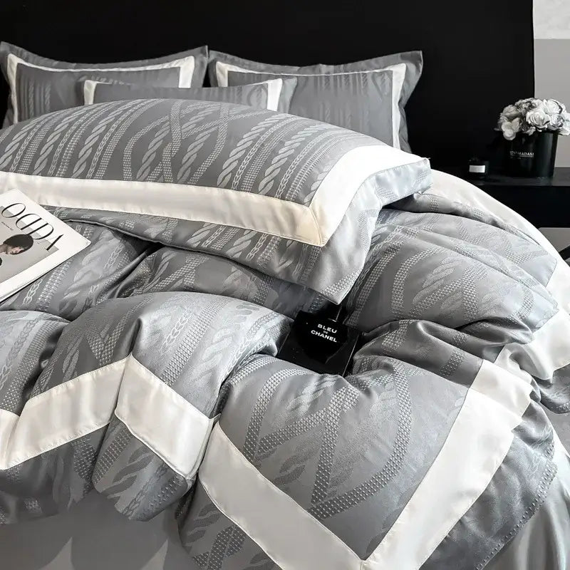 Gray and white patterned satin duvet cover set with subtle woven design and crisp white piping along edges