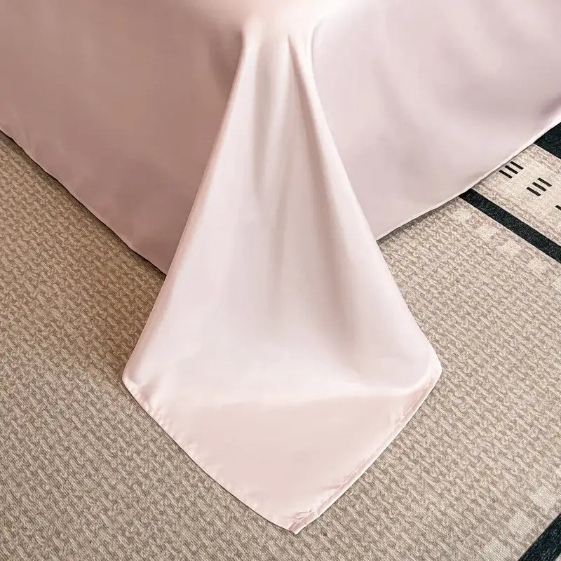 Soft blush pink satin jacquard duvet cover set with white piping featuring a smooth flowing drape for bedroom use
