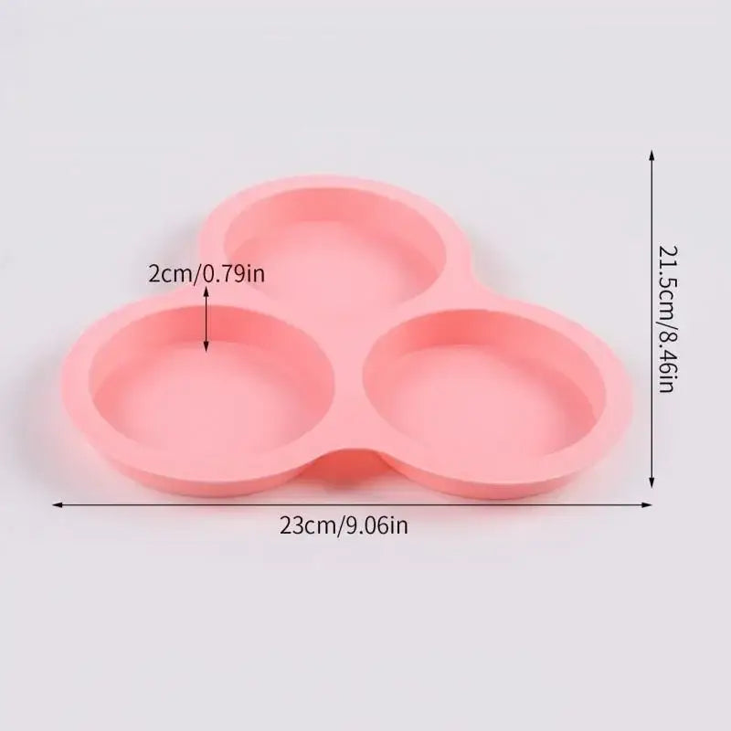 Pink silicone egg mold pancake shaper with three rounded shallow wells for cooking eggs or mold pancakes
