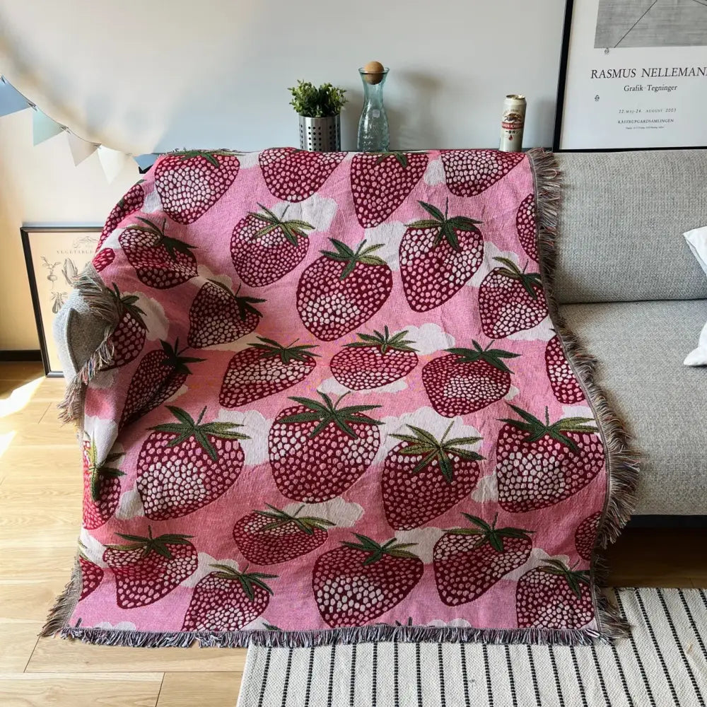 Pink strawberry patterned knitted blanket with fringed edges used as bedroom sofa cover decorbites cat strawberry