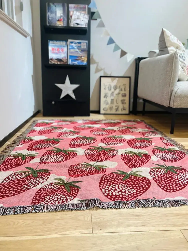 Pink strawberry patterned woven rug with fringed edges for use as a knitted blanket or decorbites cat strawberry cover