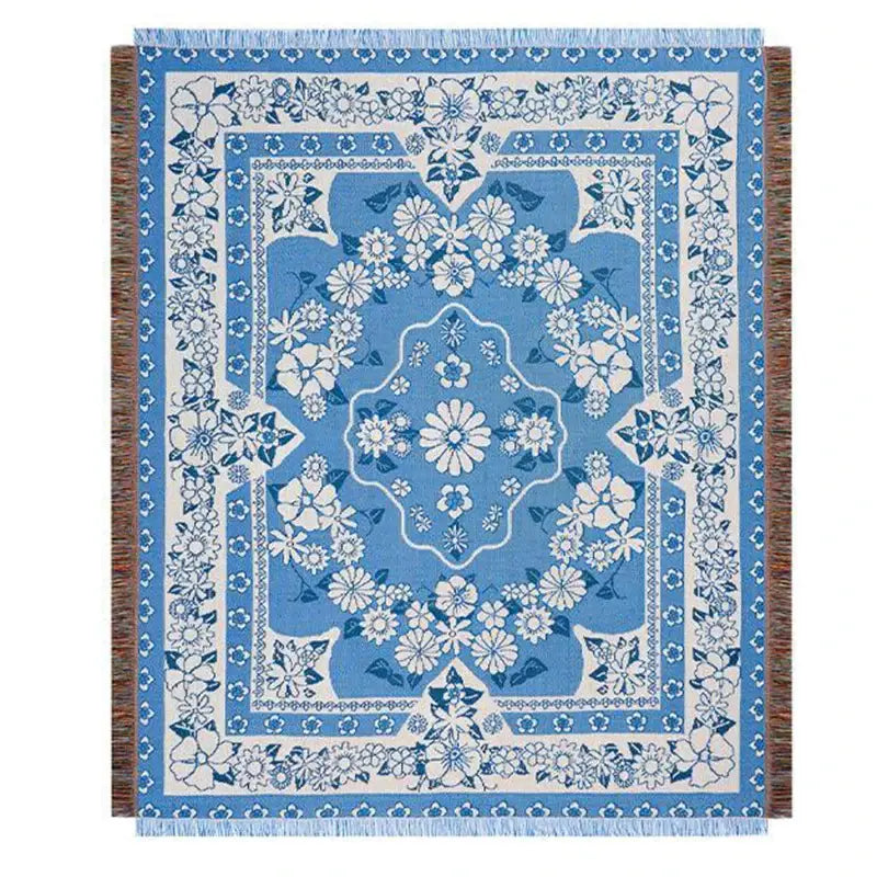 Blue floral knitted blanket with cream accents and fringed edges used as a cat strawberry knitted decorbites throw