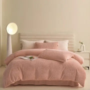 Pink textured winter fleece bedding set with duvet cover and matching pillows on a tufted headboard bed