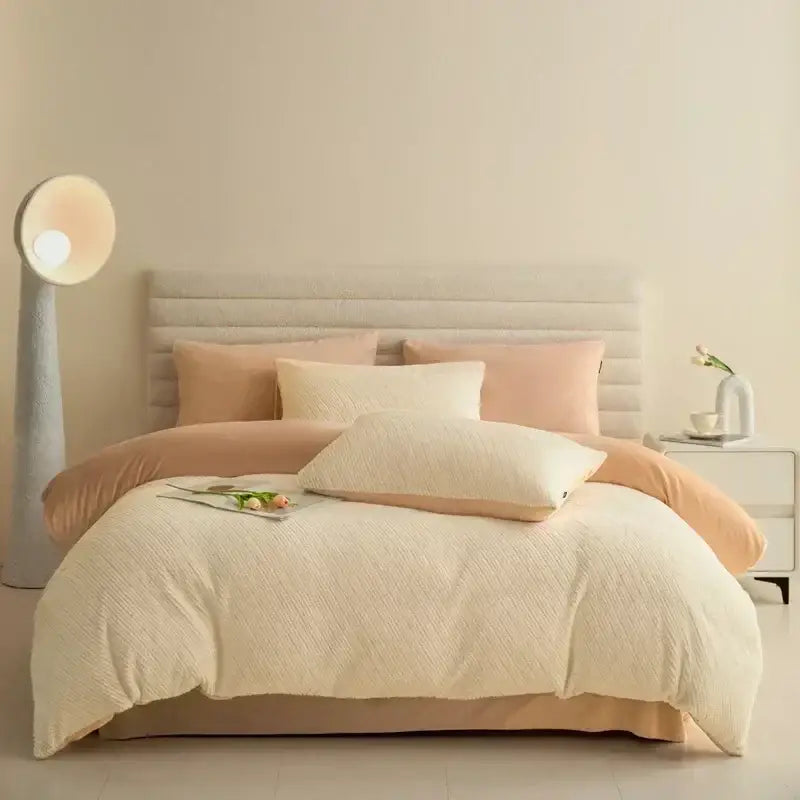 Cream-colored textured quilted duvet set with peach accent pillows and bed skirt in pink winter fleece bedding set