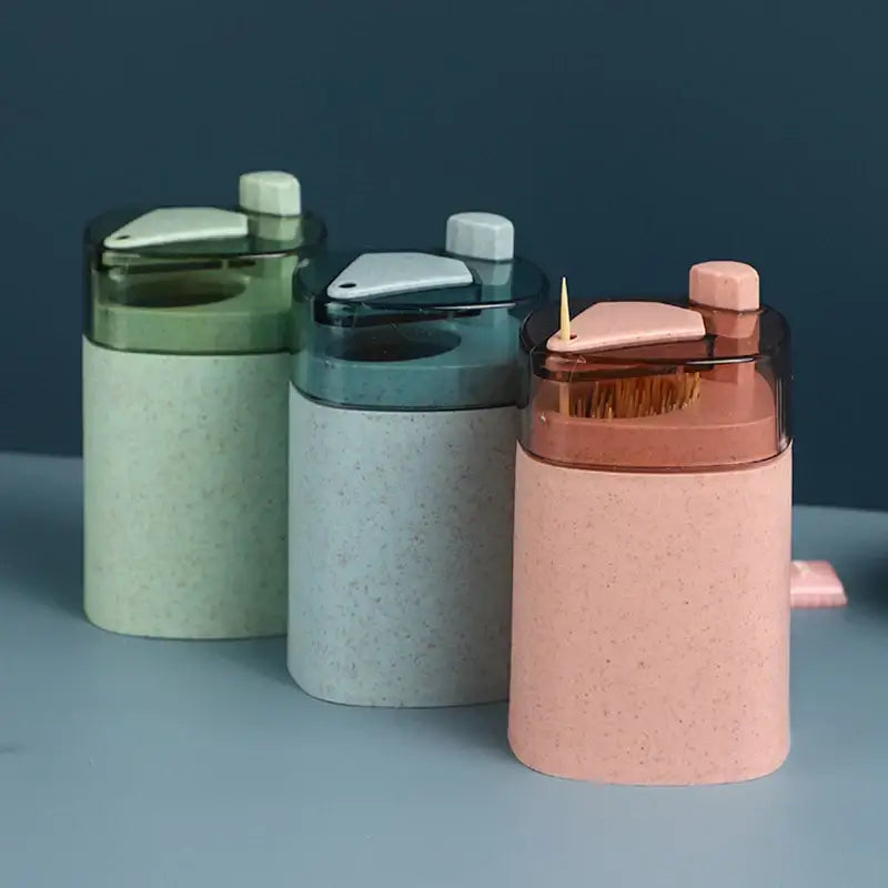 Pink and translucent automatic toothpick dispenser holder with pastel speckled bamboo texture and triangular compartment