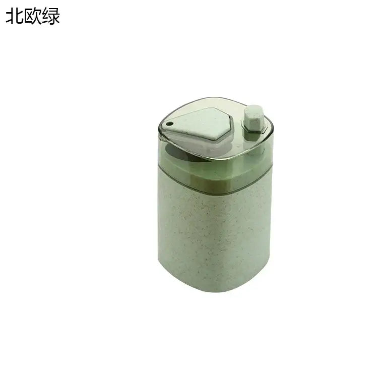 Pink and translucent automatic toothpick dispenser holder with a textured green pencil sharpener and clear lid with hex button