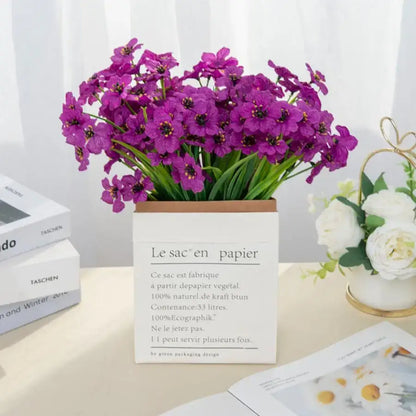Vibrant purple artificial cherry blossoms arranged in a white paper box with french text for wedding decor
