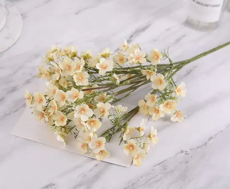 Pink and white artificial flowers babys breath wedding bouquet with cream and peach decorbites imitation flower on marble surface