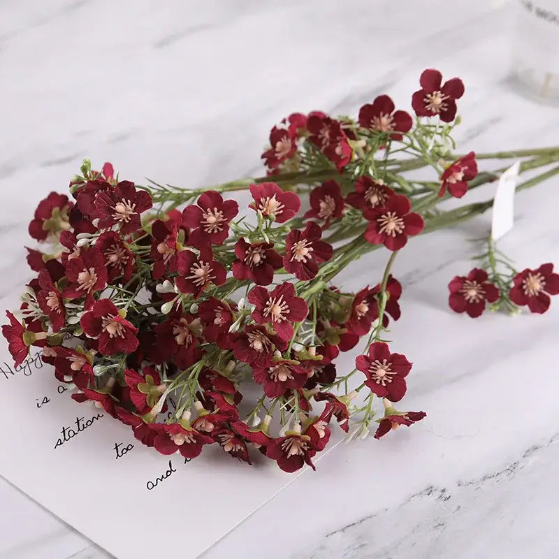 A decorbites imitation flower artificial bouquet of deep red flowers with pink centers and green stems for wedding decor
