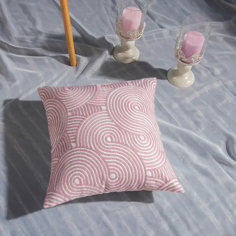 A soft pink decorbites cotton flower embroidered geometry pillow with intricate white swirl patterns for living room decor