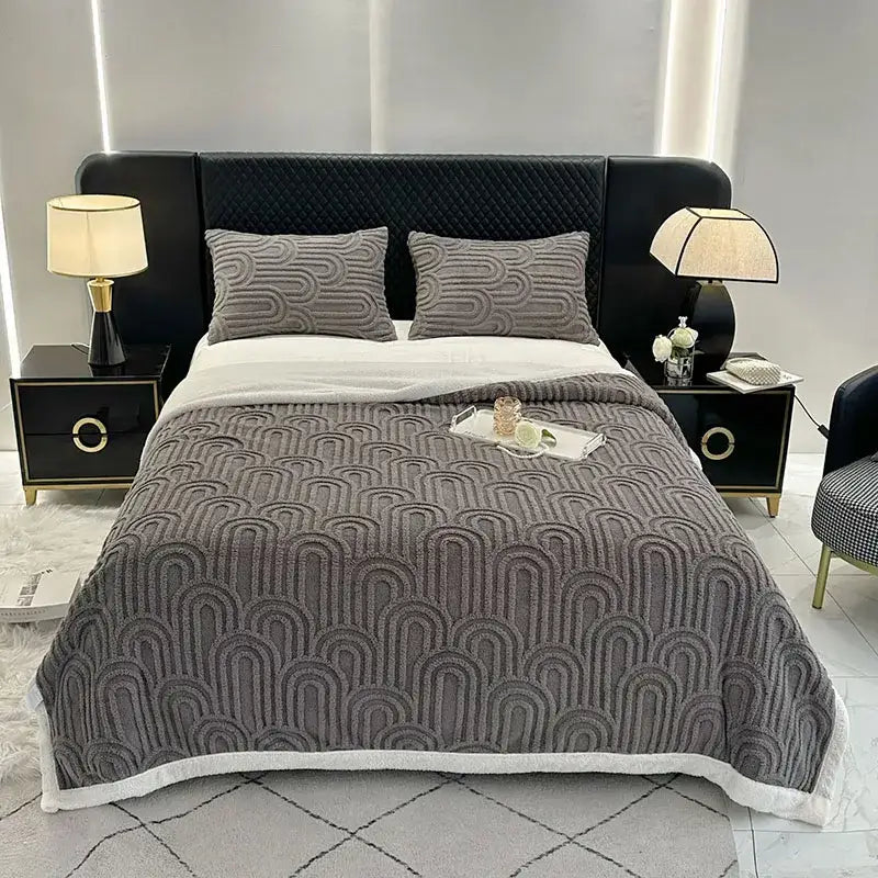 Gray quilted plush blanket with textured wave pattern and white fleece trim in double layered flannel arch design